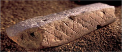 Ochre rocks adorned with scratched geometric patterns at Blombos Cave
